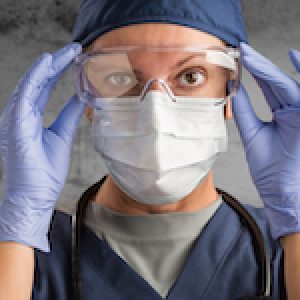 Female Doctor or Nurse Wearing Scrubs and Protective Mask and Goggles Banner