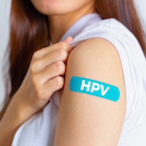 HPV (Human Papillomavirus) Teenager woman showing off an blue bandage after receiving the HPV vaccine.viruses Some strains infect genitals and can cause cervical cancer. Woman health concept.