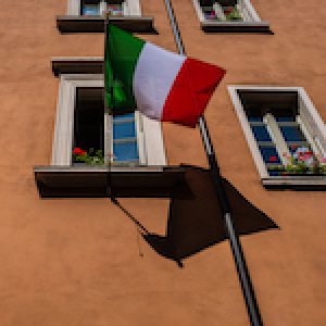Floating Italian flag on facade of an old building in Brescia, Lombardy (Italy).