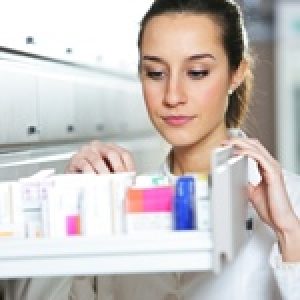 woman pharmacist reaching for medicine