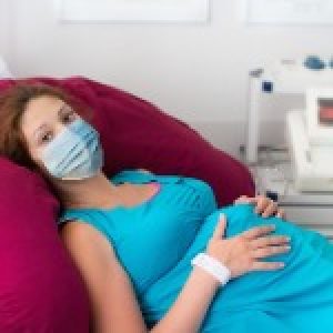 pregnant-woman-in-clinic-wearing-face-mask-picture-id1251201127