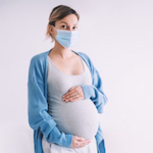 Young pregnant woman in medical mask hugging belly. Concept protection and prevention during viruses, mother care of her and  unborn baby health